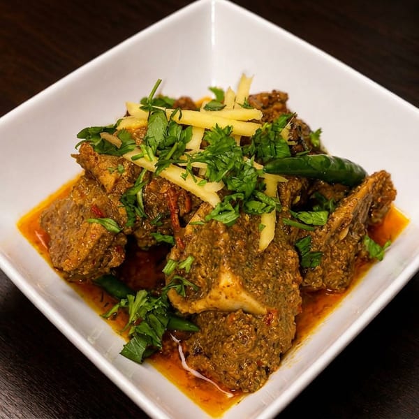 Savory meat curry with a rich sauce, garnished with fresh cilantro, ginger, and green chilies.